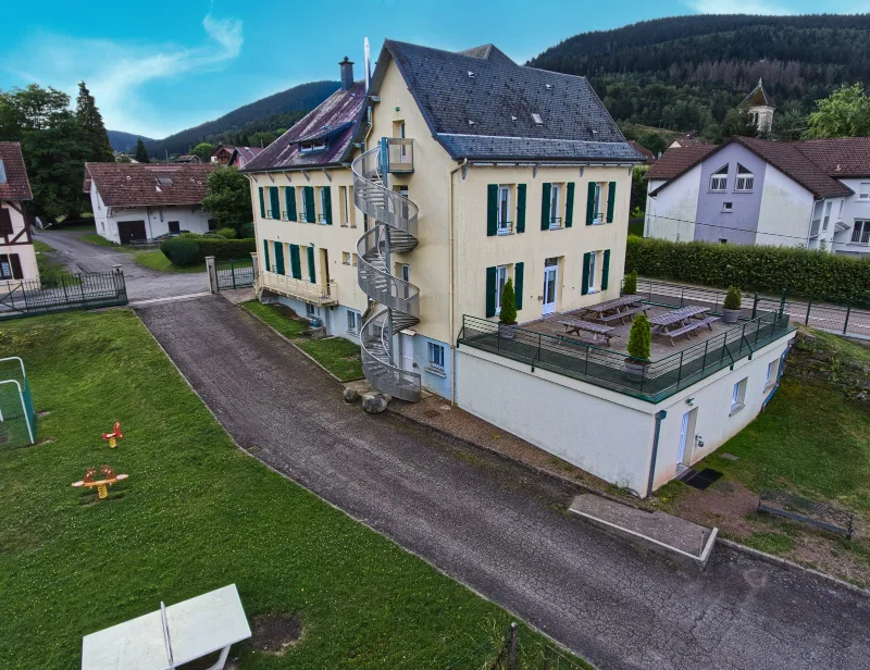 Vue aérienne diurne de la maison avec jardin, terrasse couverte et escalier extérieur en colimaçon