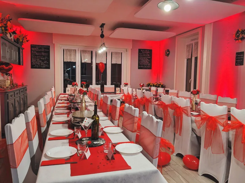 Grande salle à manger décorée pour un repas de groupe avec longue tablée