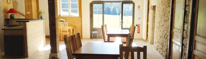 Salle de repas lumineuse avec vue dégagée sur les montagnes du Jura