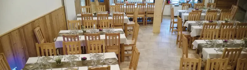 Grande salle à manger avec tables dressées pour accueillir un groupe nombreux