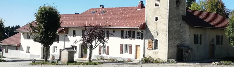 Façade de l'Ermitage des Frasses avec clocher, architecture jurassienne typique