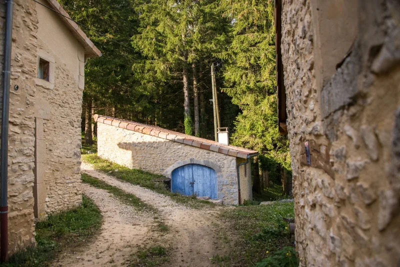 Cour intérieure du hameau avec porte en bois bleue traditionnelle