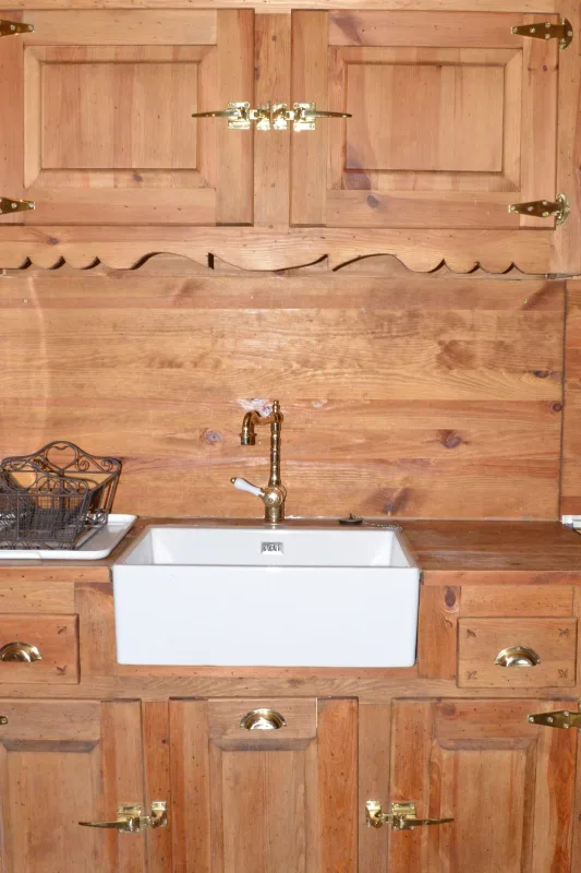 Cuisine équipée en bois avec évier et rangements traditionnels