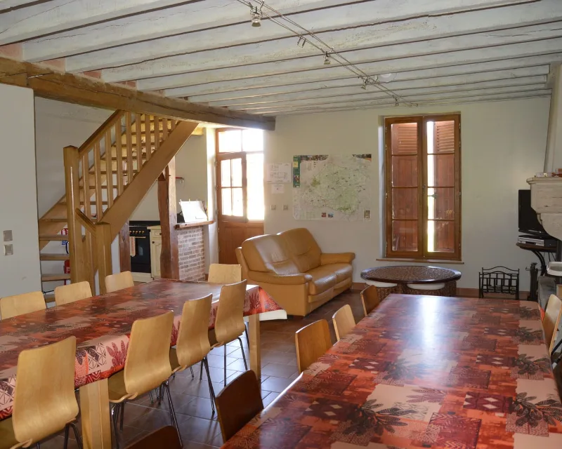 Grande salle à manger et salon avec poutres apparentes pour un groupe