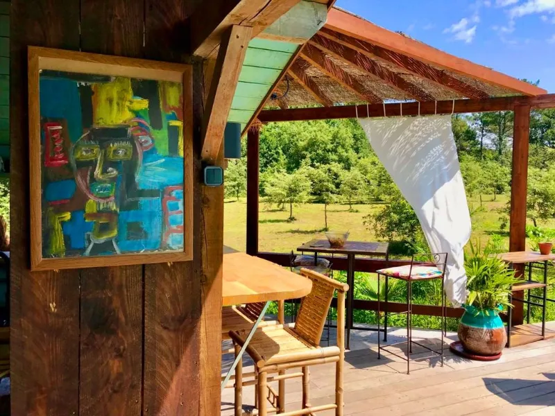 Tiki bar extérieur avec pergola en bois et vue sur le parc