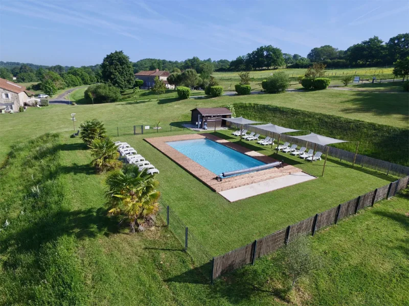 Vue aérienne de la piscine chauffée 12x6m entourée de transats et de palmiers