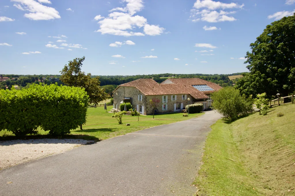 Gîte de groupe VéloGîtes à Availles-Limouzine — Vue d'ensemble du domaine, ancienne grange en pierre entourée de prairies vallonnées, capacité 40 personnes