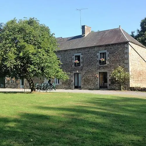 Façade en pierre normande du Domaine de Normandie avec grand jardin arboré