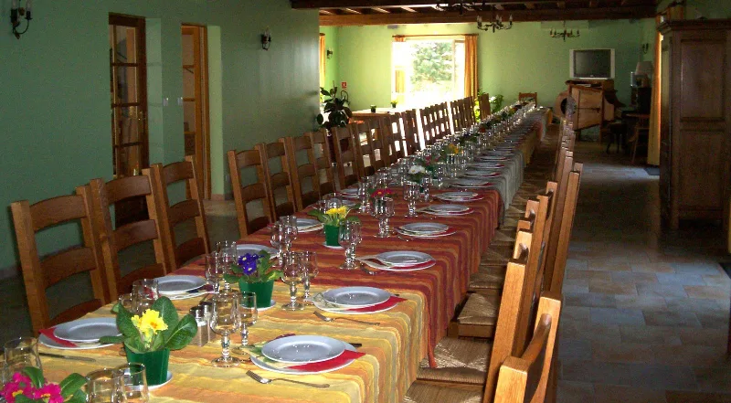 Salle de réception spacieuse avec grandes tables pour recevoir jusqu'à 80 convives