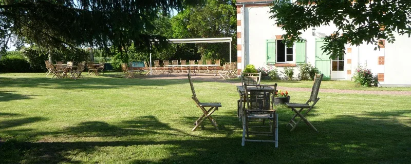 Grande terrasse extérieure ombragée avec tables pour les repas de groupe