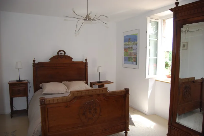 Chambre confortable aménagée avec literie de qualité et fenêtre sur jardin