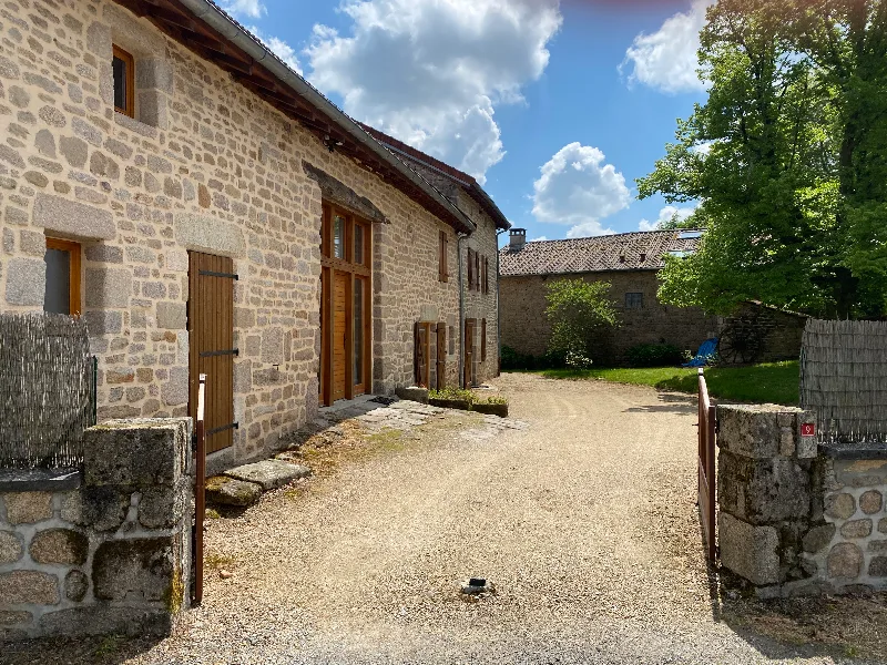 Cour intérieure pavée entre les bâtiments en pierre du corps de ferme