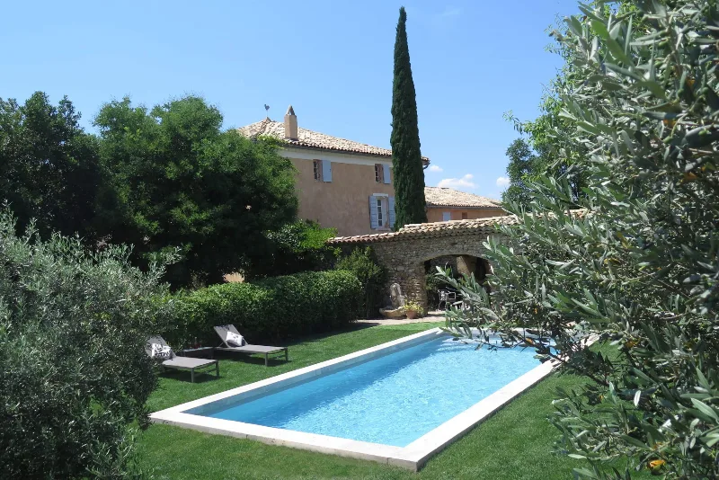 Bastide en pierre entourée de cyprès avec piscine extérieure et transats