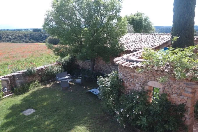 Vue aérienne du bâtiment en pierre, toiture de tuiles et jardin avec mobilier extérieur