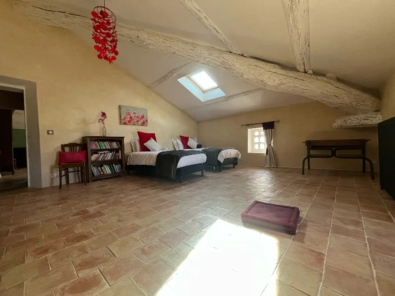 Chambre mansardée avec lits jumeaux, poutres apparentes et velux