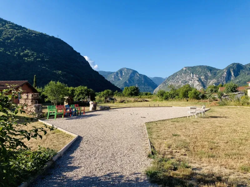 Terrasse en gravier avec bancs colorés et vue sur les montagnes environnantes