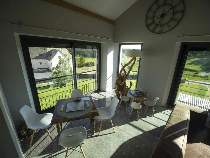 Cuisine moderne ouverte avec îlot central en bois, mur en pierre et mezzanine
