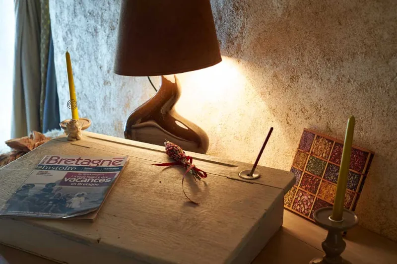 Table de chevet en bois avec lampe allumée et magazine Bretagne