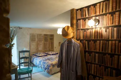 Chambre rustique avec lit double, peignoir et bibliothèque en trompe-l'œil