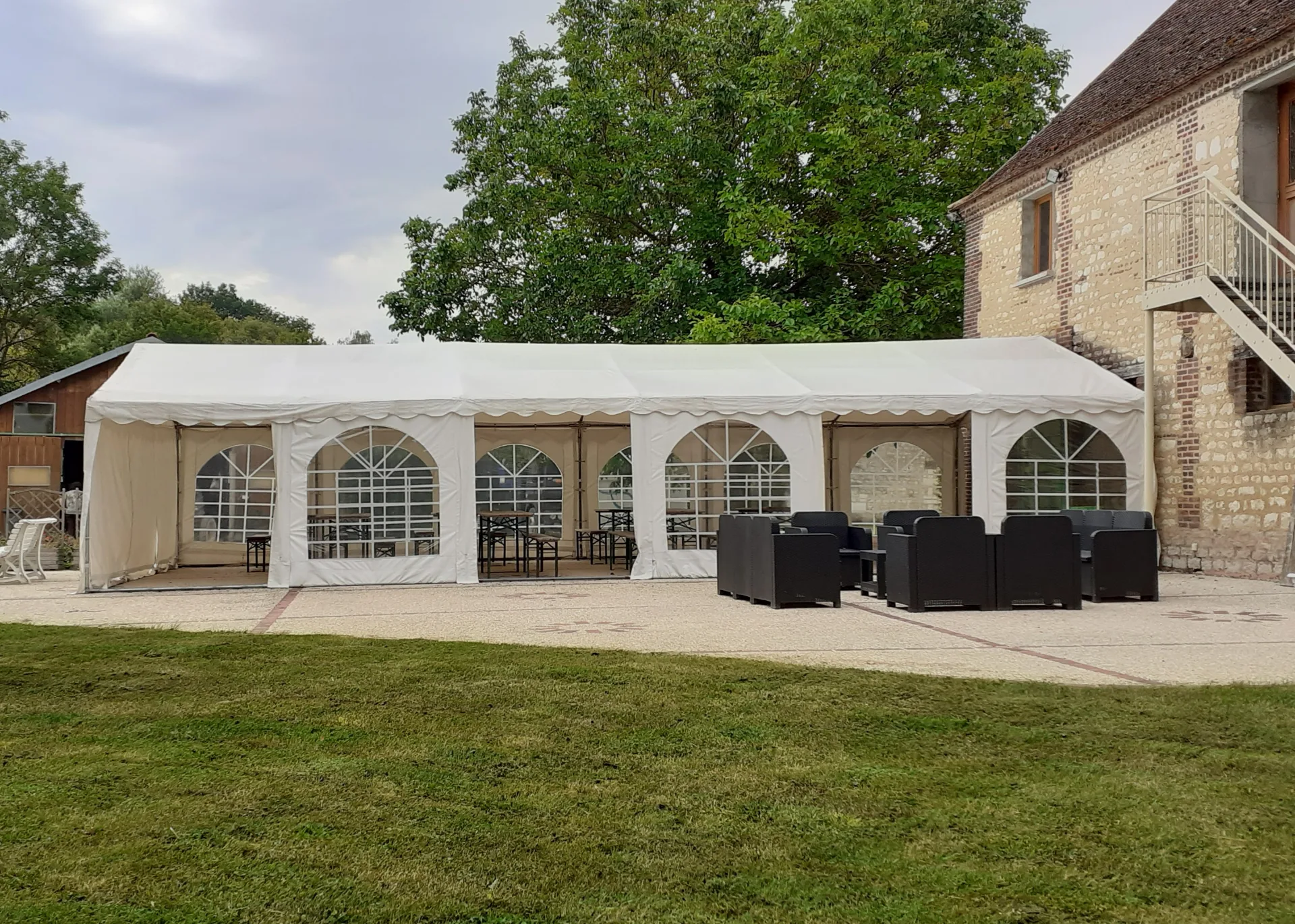 Gîte de groupe Ferme de la Renaissance à Thuisy — Terrasse et jardin de la Ferme de la Renaissance avec vue sur la campagne champenoise, capacité 26 personnes