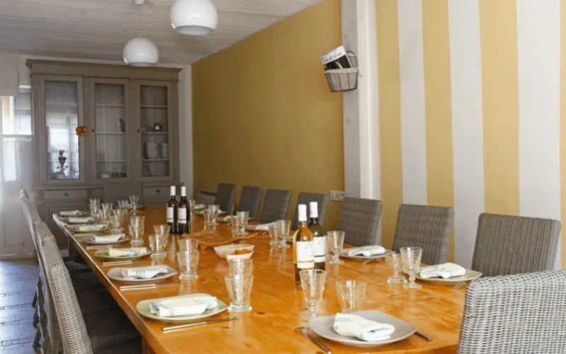 Grande salle à manger dressée avec table en bois pour un repas de groupe