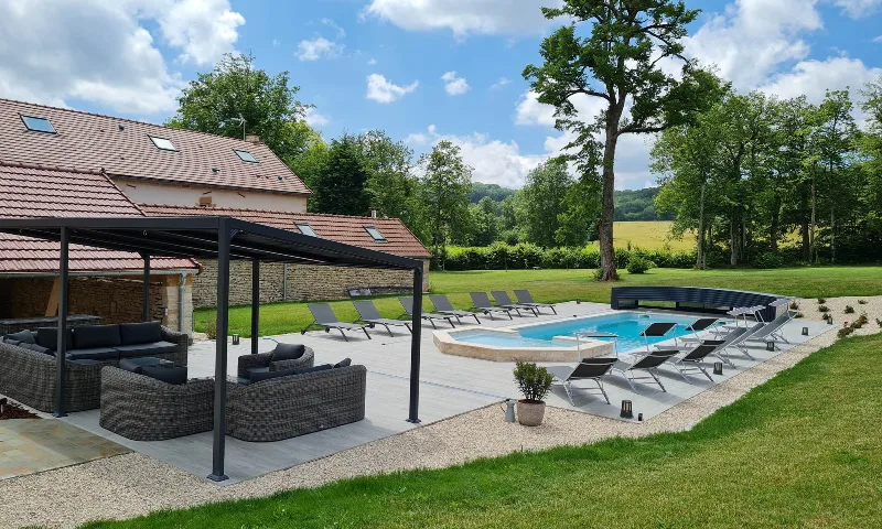 Piscine chauffée et terrasse avec transats sous pergola et salon extérieur
