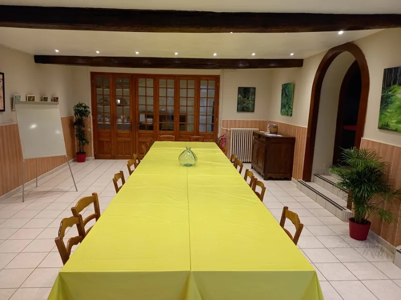 Grande salle de réception avec longue table dressée et nappe jaune