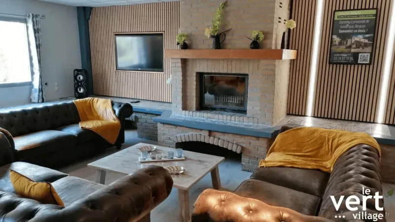 Salon convivial avec canapés en cuir, cheminée en briques et coin télévision