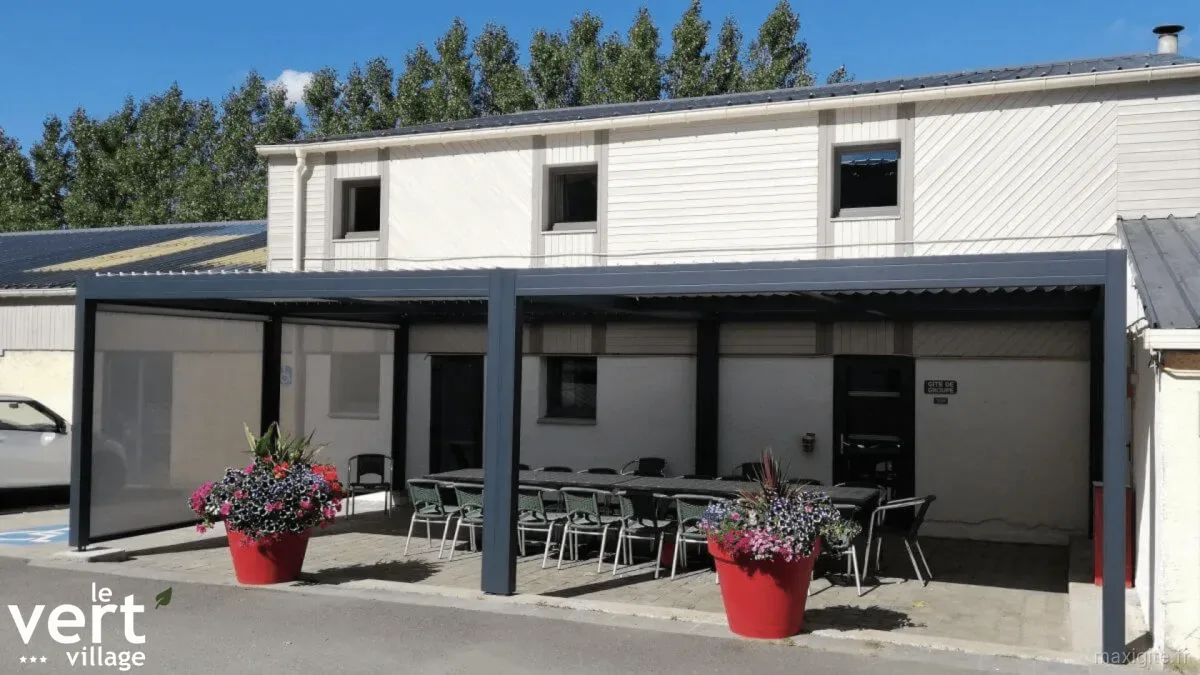 Gîte de groupe Le Vert Village - Gîte de groupe à Crochte — Façade du Vert Village avec terrasse couverte, tables et pergola pour le gîte de groupe, capacité 25 personnes