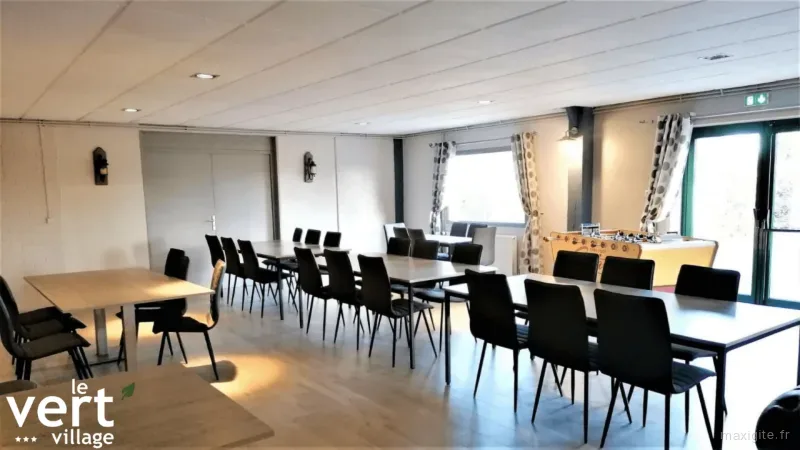 Grande salle à manger lumineuse avec plusieurs tables et chaises pour recevoir un grand groupe