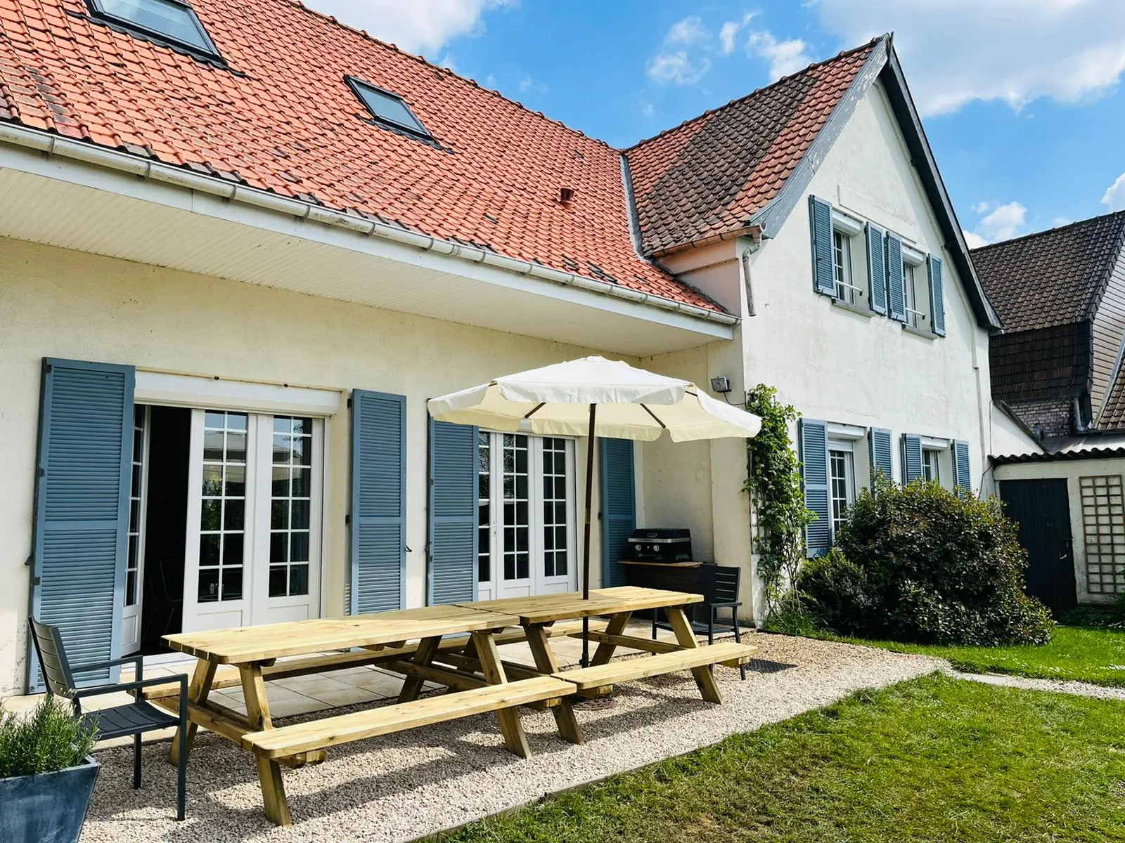 Gîte de groupe La Réserve - Gîte de charme à Clairmarais — Façade de La Réserve, maison de charme en briques avec toit en tuiles et terrasse pique-nique, capacité 15 personnes