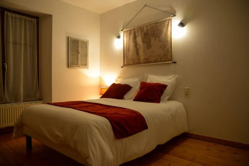 Chambre double avec tête de lit en pierre et éclairage tamisé