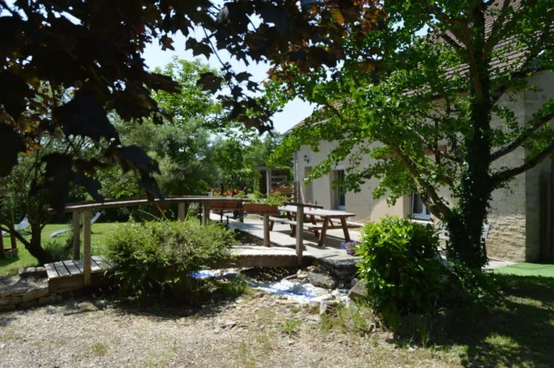 Jardin avec petit pont en bois et ruisseau traversant la propriété