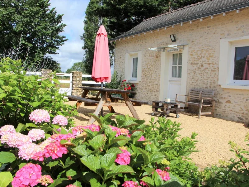 Cour centrale du hameau avec bâtiments en pierre typiques de la Sarthe
