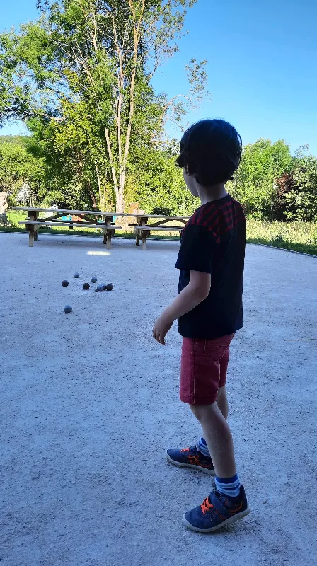 Groupe jouant au ballon dans le grand jardin arboré face à la bâtisse
