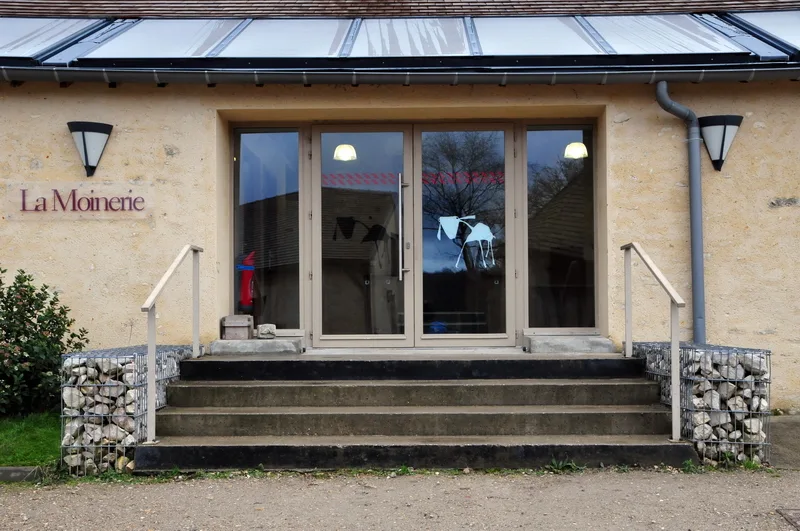 Gîte de groupe La Moinerie - Ecosite de Villarceaux à Chaussy — Façade en pierre de La Moinerie avec enseigne et entrée vitrée, capacité 60 personnes