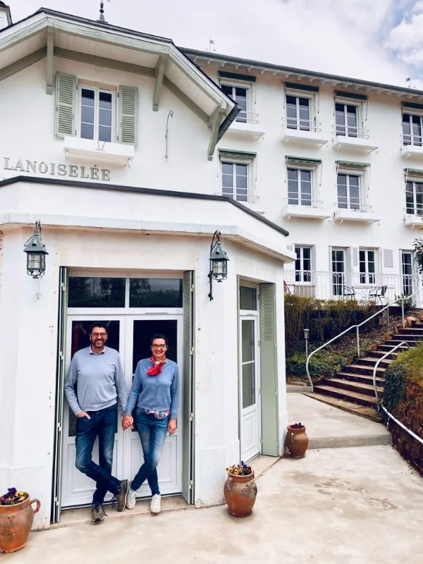 Façade blanche de la Maison Lanoiselée, ancien hôtel 1900 avec enseigne et terrasse d'entrée