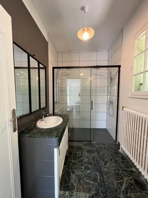 Salle de bain avec douche à l'italienne vitrée et vasque sur meuble marbre vert
