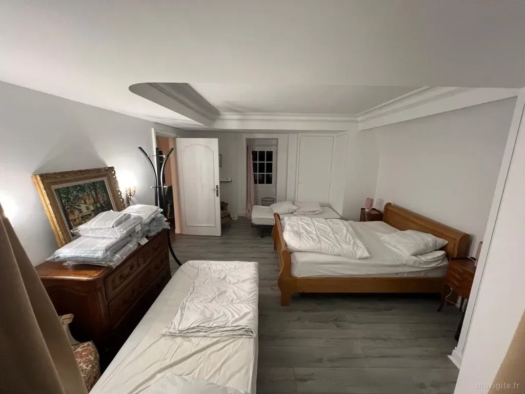 Chambre spacieuse avec deux lits en bois et commode ancienne