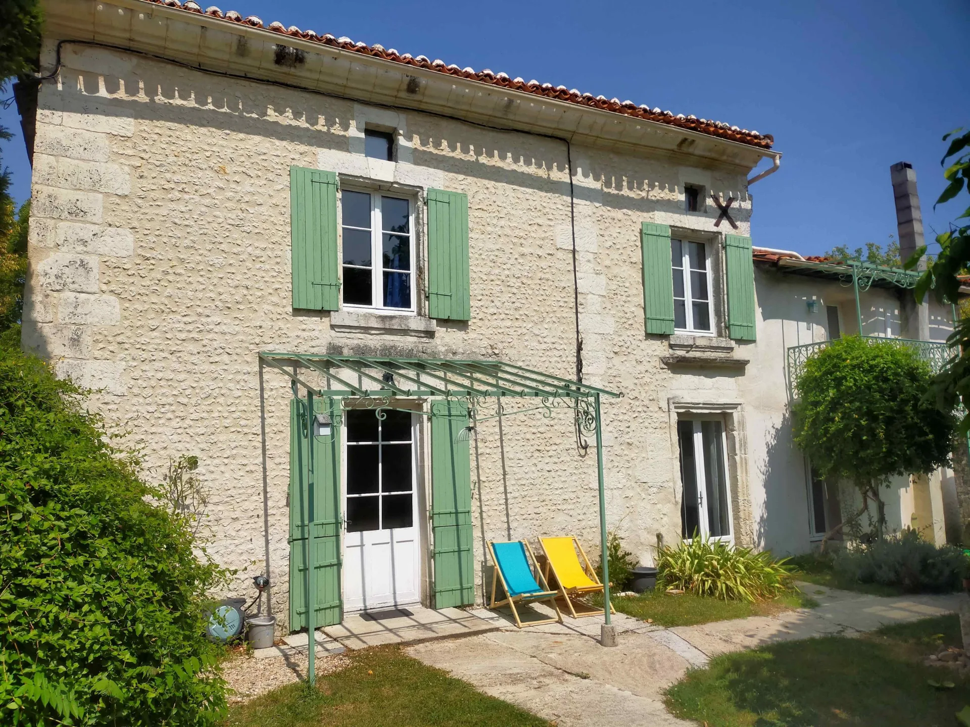 Gîte de groupe Domaine Jasmin à Bellon — Maison principale du Domaine Jasmin, façade en pierre charentaise entourée de verdure, capacité 50 personnes
