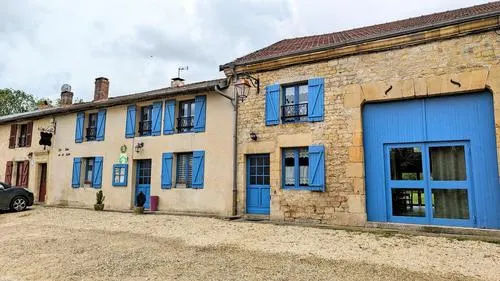 Gîte de groupe Les Gîtes de la Lotée à Halles-sous-les-Côtes — Façade en pierre du gîte avec volets bleus, dans le village de Halles-sous-les-Côtes, capacité 28 personnes