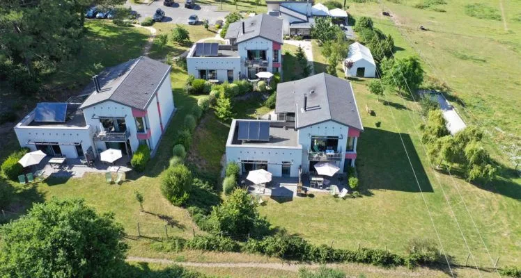 Gîte de groupe Les Hauts de Toulvern à Baden — Vue aérienne du domaine avec plusieurs maisons entourées de verdure et terrasses privées, capacité 18 personnes