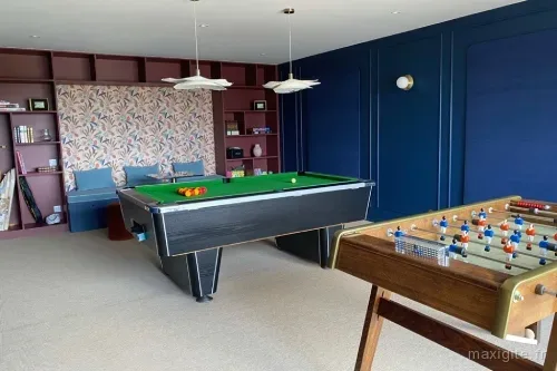 Salle de jeux avec billard et espace détente pour tous les âges