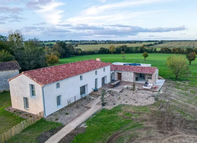 Vue aérienne de la façade en pierre du domaine entouré de verdure