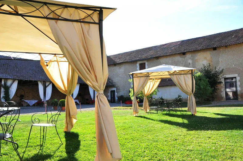Cour extérieure avec pavillons de réception et mobilier de jardin en fer forgé