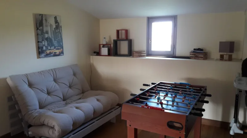 Salle de jeux avec baby-foot et canapé, espace détente pour les groupes
