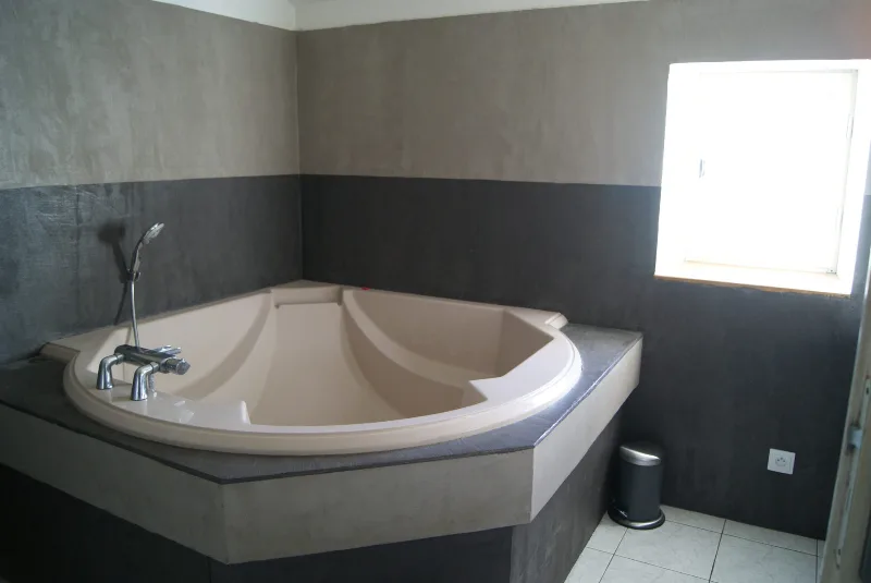 Salle de bain avec baignoire d'angle et douche