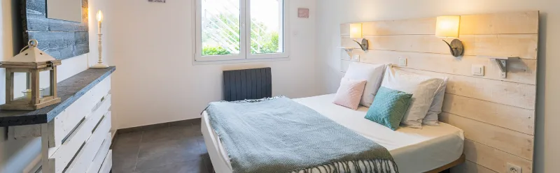 Chambre avec lit double, miroir et coiffeuse en bois recyclé