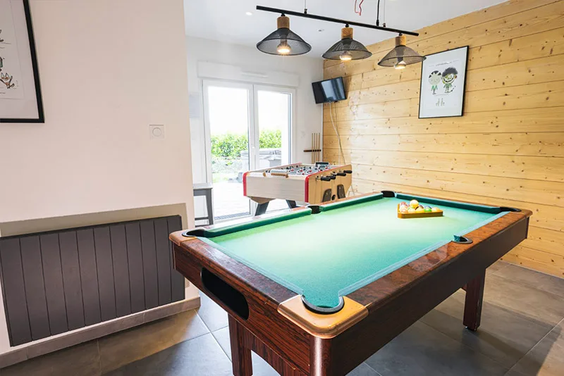 Salle de jeux avec billard américain et baby-foot