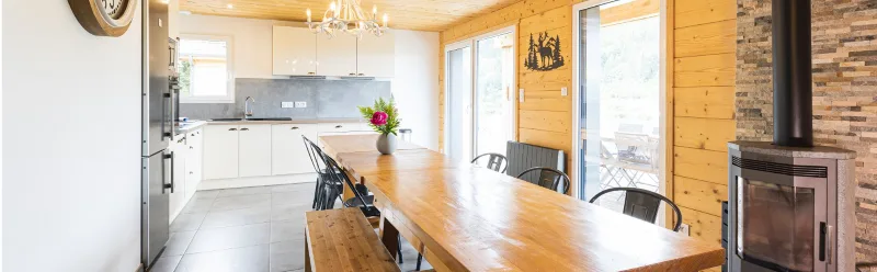 Cuisine ouverte et grande table à manger en bois avec poêle à bois